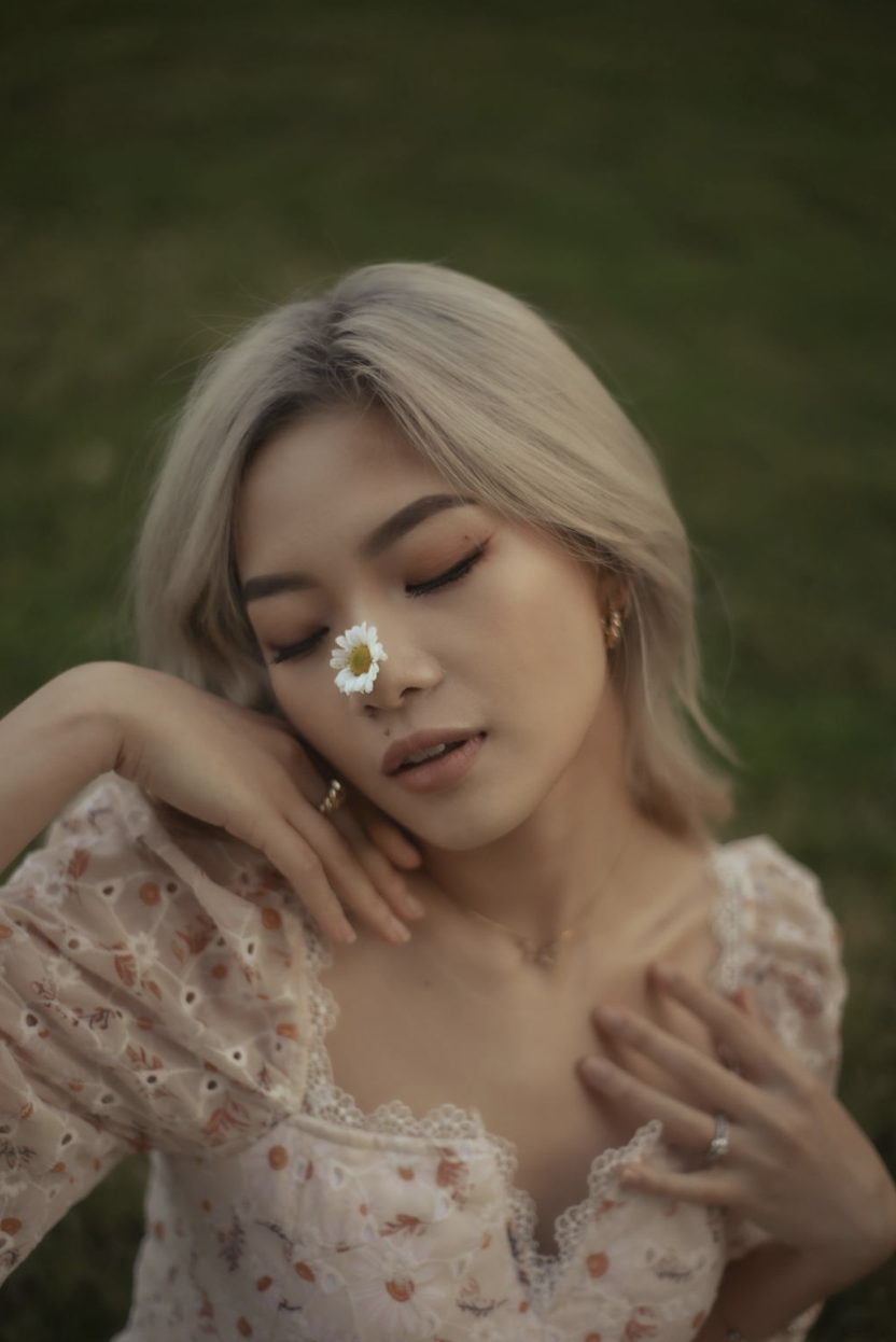 Cinematic portrait with a daisy, eyes closed