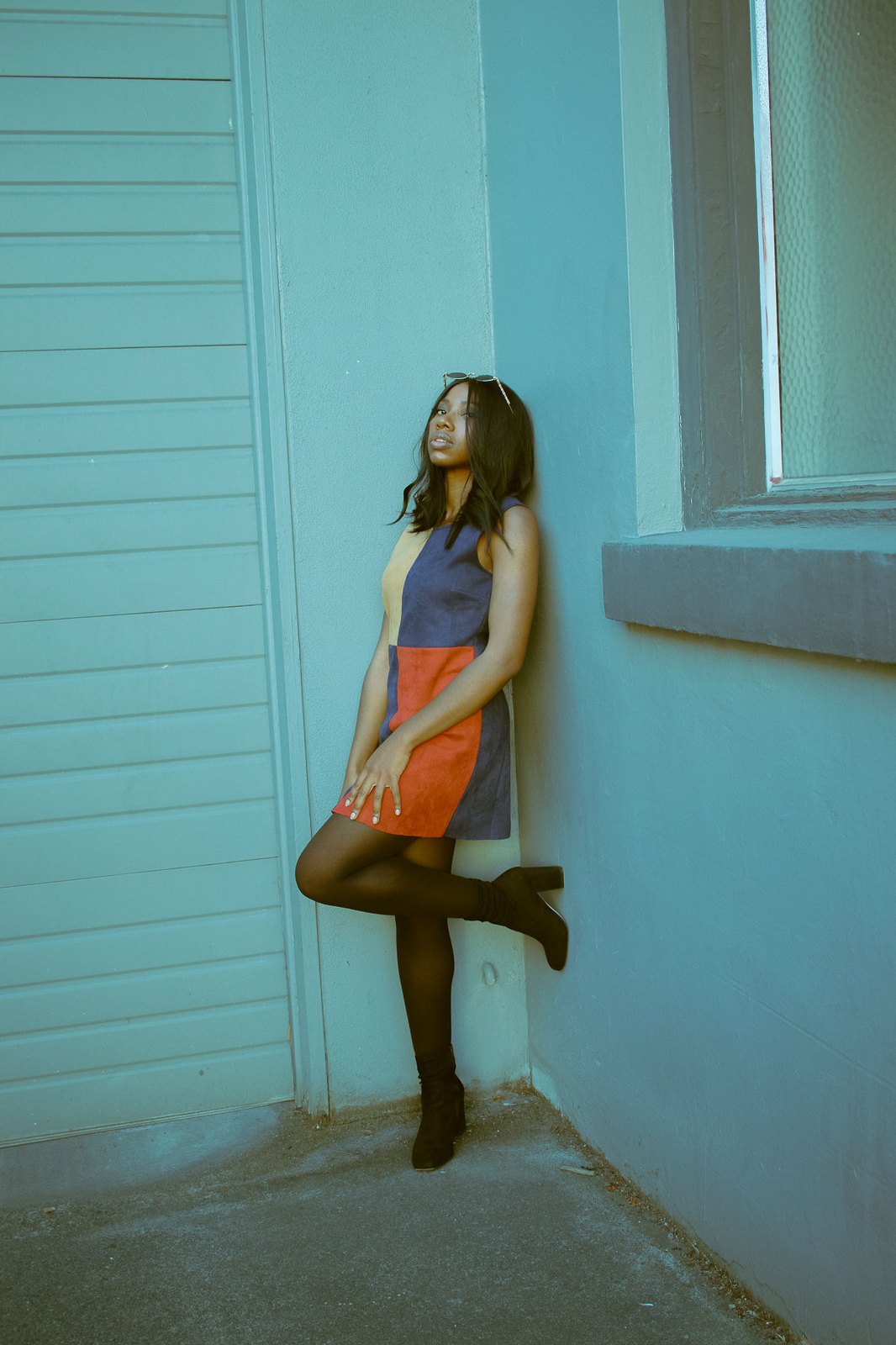 Styled portrait leaning against a teal wall